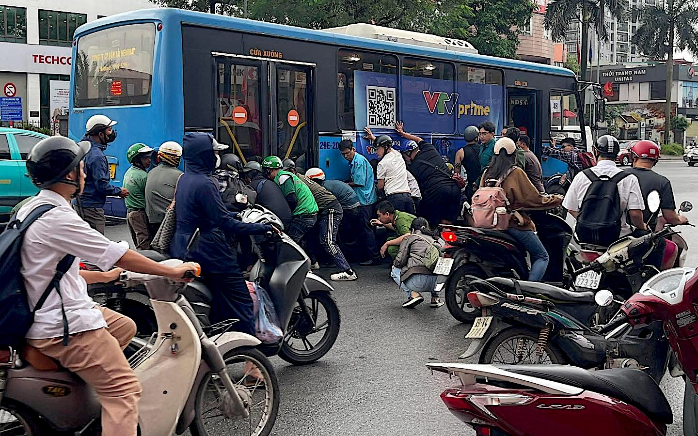 Cận cảnh người dân nâng xe buýt cứu tài xế mắc kẹt